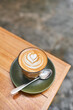 © Helen Yin/Stocksy - Latte on a green saucer with latte art