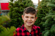 Smiling Boy Surrounded By Pine Trees