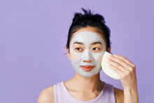 Beautiful Young Woman Removing Face Mask With A Sponge O