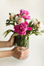 Hands Carring Glass Vase With Flowers Inside
