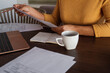 © Milles Studio/Stocksy - Crop freelancer checking papers at table
