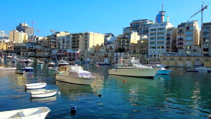 Poster - Spinola Bay harbor with many small fishing boats and modern residential quarters on the background, St Julians, Malta