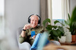 © ALTO IMAGES/Stocksy - Smiling senior man listening to music at home