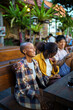 © Jovo Jovanovic/Stocksy - Two women laughing together at table with friends