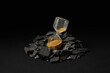 © Yaroslav Danylchenko/Stocksy - Sandglass with golden sand pile of coal.