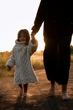 Little Charming Daughter Walking At Sunset With Mother.