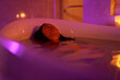 © Jovo Jovanovic/Stocksy - Young woman relaxing in bathtub filled with water