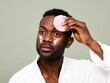 © ohlamour studio/Stocksy - Man using brush pad as part of his skincare routine