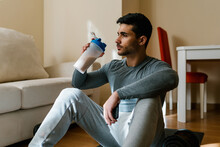 Athlete With Protein Drink Taking Break At Home