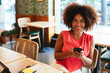 © BONNINSTUDIO/Stocksy - Cheerful latin freelancer using smartphone in cafe