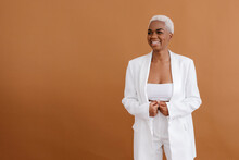 Cheerful African American Woman In White Clothes On Brown Background