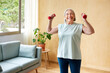 © ALTO IMAGES/Stocksy - Smiling mature woman exercising with dumbbells