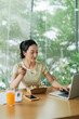 © Marc Tran/Stocksy - Businesswoman eating from lunch box in office