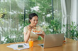 © Marc Tran/Stocksy - Young businesswoman eating a salad while working in office.
