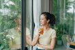 © Marc Tran/Stocksy - Attractive young woman holding a glass of orange juice