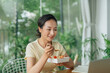 © Marc Tran/Stocksy - Busy businesswoman having lunch in office