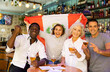 © JackF - Excited diverse soccer fans with flag of Peru rejoicing winning game with glasses of beer in the pub