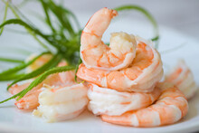Fresh shrimp on white plate, cooked shrimps prawns for seafood with herb cannabis leaf, cooking boiled shrimp