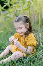 Portrait Of Toddler Girl Playing With Milkweed Seeds