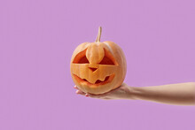 Pumpkin With Halloween Carving In Female Hand.