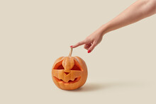 Carved Pumpkin Touched By Woman's Hand.