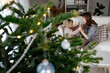 © Sergey Narevskih/Stocksy - Mother and daughter playing on couch near Christmas tree at home