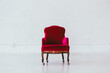© Carter Wright/Stocksy - Vintage red velvet wingback chair in a white brick studio