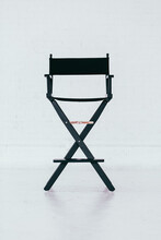 Black Director's Chair In A Bright And Airy White Brick Warehouse