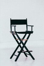 Black Director's Chair In A Bright And Airy White Brick Warehouse