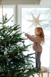 © Sergey Narevskih/Stocksy - Child hanging glass ball on Christmas tree
