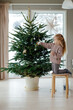 © Sergey Narevskih/Stocksy - Child decorating Christmas tree with toys