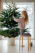 © Sergey Narevskih/Stocksy - Blond kid decorating Christmas tree
