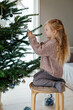 © Sergey Narevskih/Stocksy - Child decorating Christmas tree