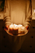 Anonymous Female Holding Plate With Burning Candles 