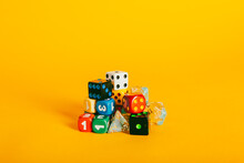 Various Colorful Dice Pieces On A Vibrant Yellow Background