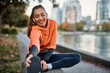 © Drazen - Happy female athlete stretching while warming up for sports training outdoors.