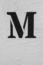 Distressed Brick Wall Background With A Painted Letter M.