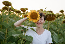 A Woman Is Standing In A Field With Sunflowers And Having Fun