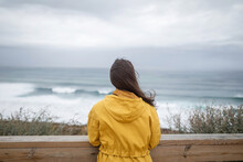 Young Woman With Raincoat By The Sea