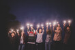 © Johnstocker - Group of young friends holding and play with fire burning sparklers