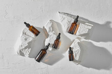 Bottles With Pipette For Essential Oil, Stones On White Background