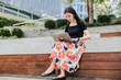 © Heng Yu/Stocksy - Businesswoman  working on a laptop outdoor