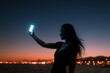 © Ibai Acevedo/Stocksy - Happy woman taking selfies at sunset