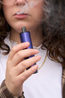 © Rowena Naylor/Stocksy - Girl exhaling smoke after vaping