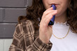 © Rowena Naylor/Stocksy - Young woman inhaling from e-cigarette