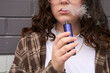 © Rowena Naylor/Stocksy - Young person using vape pen