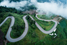 Aerial Video Top View Drone Road Photo Over Green Mountains With White Fog Floating And Paths Exciting Steep Road Way Of Travel	
