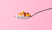 Multicoloured Cereal With Dripping Milk On Spoon 