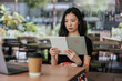 © Heng Yu/Stocksy - Young woman in a cafe reading an ebook