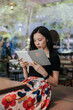 © Heng Yu/Stocksy - Young woman in a cafe reading an ebook